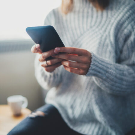 Closeup,Of,Female,Hands,Using,Modern,Smartphone,Device,At,Home,