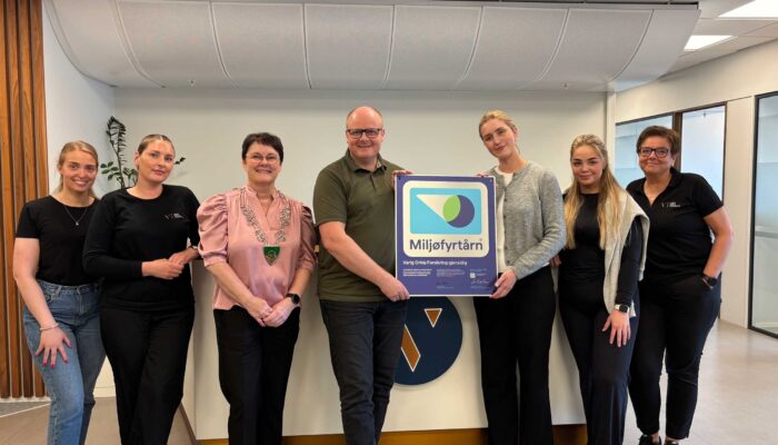 Smilende ansatte og ordfører med miljøfyrtårn plakett