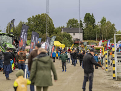 Publikum foran utstilling av kjøretøy på travbanen