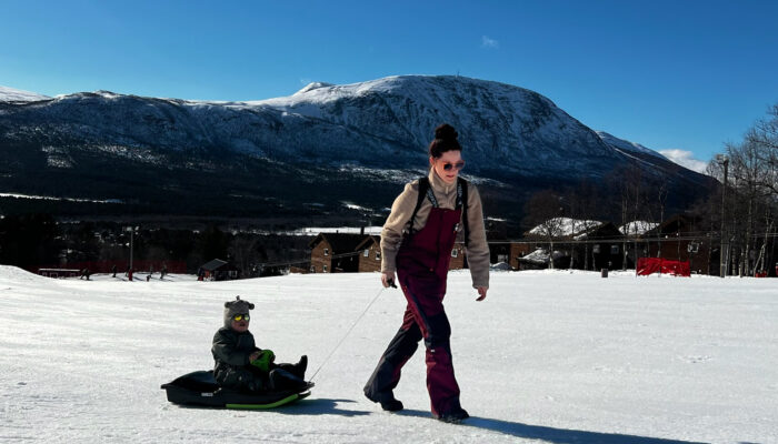 Mor og sønn i akebakke på påskeferie