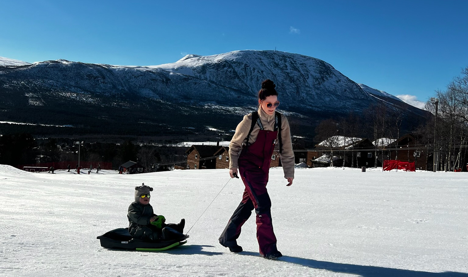 Mor og sønn i akebakke på påskeferie